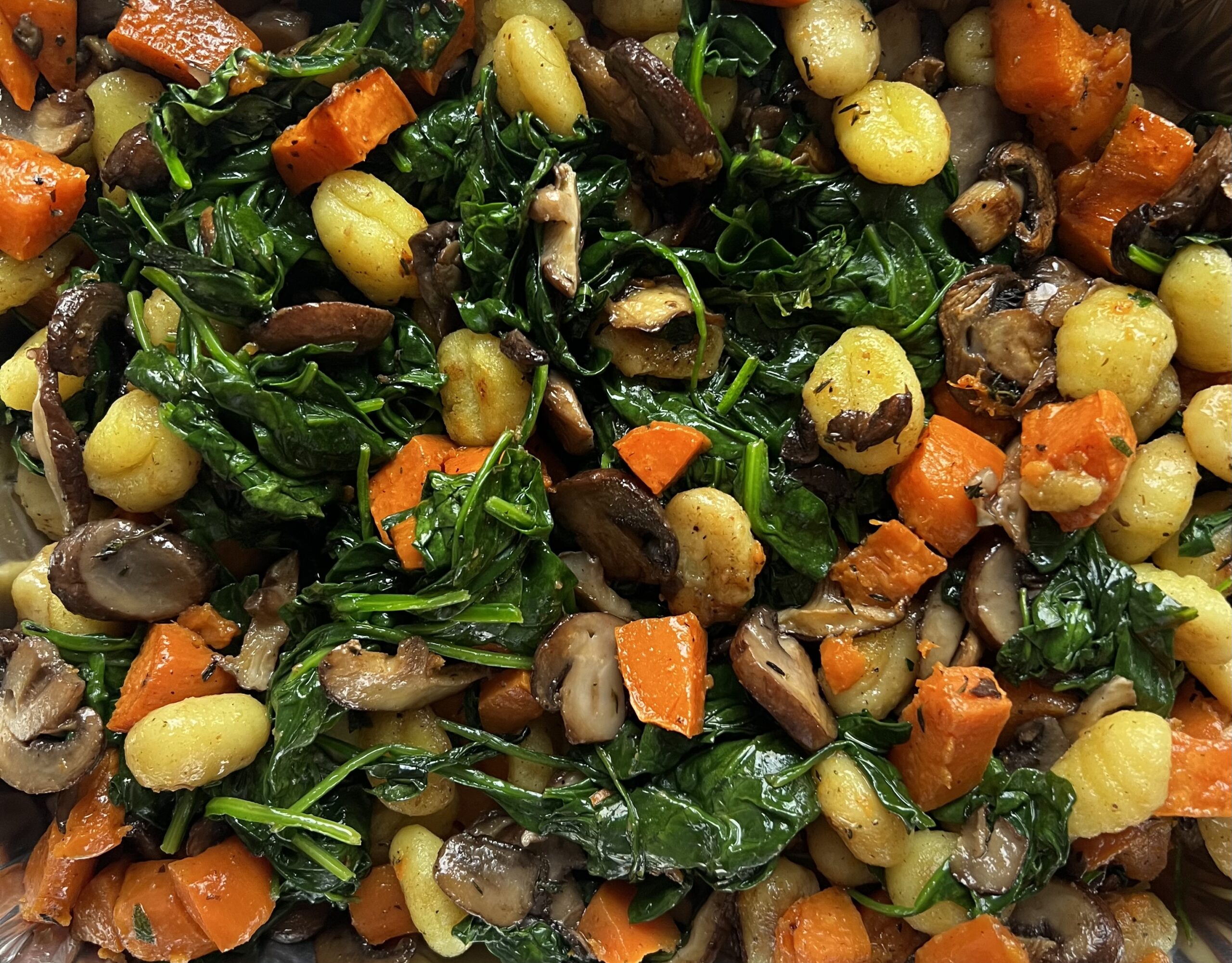 close up of finished dish with gnocchi, sweet potato, mushroom, spinach